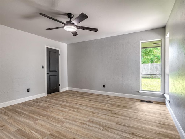 11008 Blue Sage Rd, Oklahoma City, OK 73120 - spare room with a textured wall, light wood-style floors, a ceiling fan, and baseboards