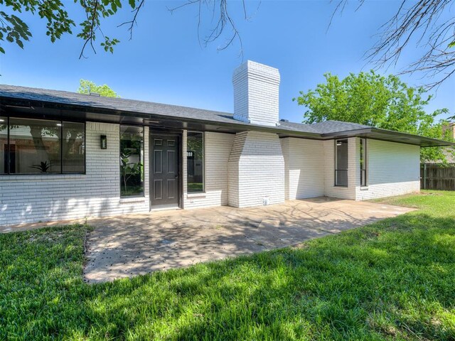 11008 Blue Sage Rd, Oklahoma City, OK 73120 - rear view of property featuring brick siding, a patio, and a chimney