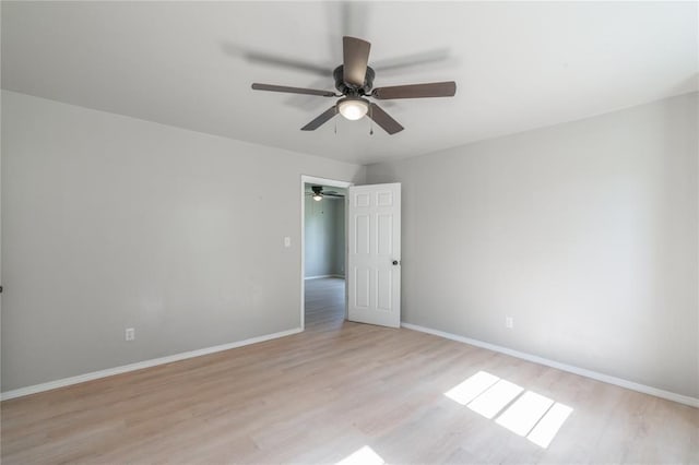 unfurnished room with light wood-style floors, ceiling fan, and baseboards