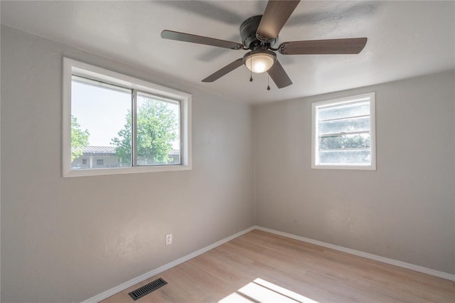 unfurnished room with wood finished floors, ceiling fan, and baseboards