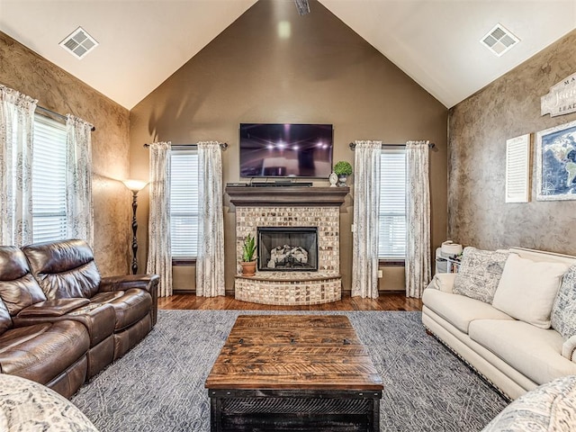 living area featuring a fireplace, wood finished floors, and high vaulted ceiling