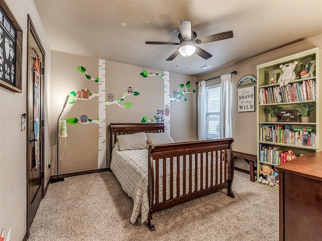 bedroom featuring light colored carpet, baseboards, and a ceiling fan