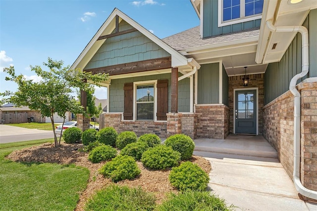 property entrance featuring board and batten siding, a porch, and a shingled roof