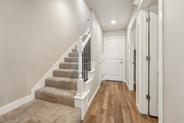 stairs with wood finished floors, baseboards, and recessed lighting