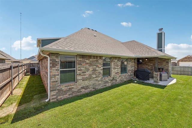 back of property with a patio area, central AC, roof with shingles, a chimney, and brick siding