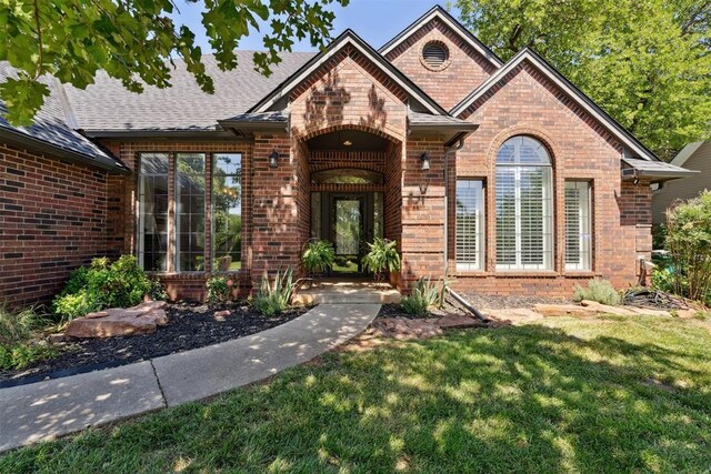 13500 Creekside Dr, Oklahoma City, OK 73131 - doorway to property with brick siding, a yard, and roof with shingles