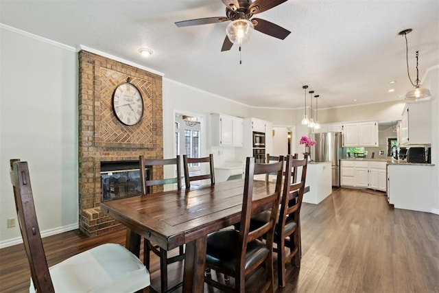 13500 Creekside Dr, Oklahoma City, OK 73131 - dining area featuring dark wood-type flooring, ceiling fan, crown molding, a fireplace, and baseboards