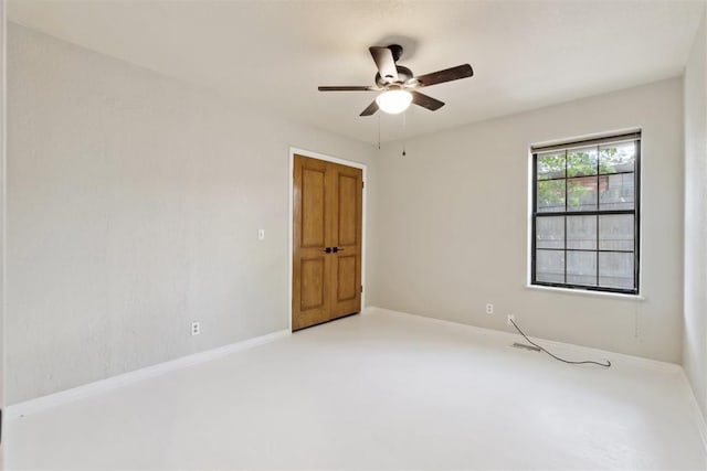13500 Creekside Dr, Oklahoma City, OK 73131 - spare room with a ceiling fan, baseboards, and concrete flooring