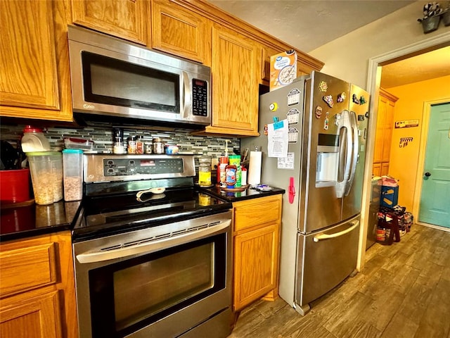 142 Skyline Dr, Chickasha, OK 73018 - kitchen with stainless steel appliances, decorative backsplash, dark wood-type flooring, and brown cabinetry