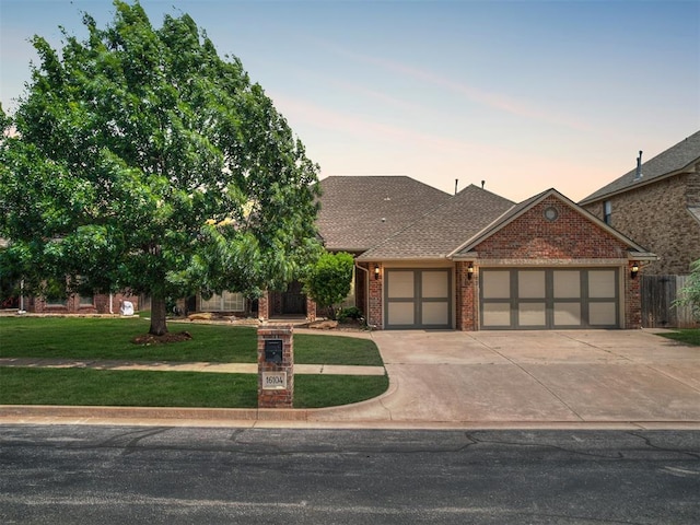 16104 Ledge Ln, Edmond, OK 73013 - view of front facade with an attached garage, brick siding, concrete driveway, and a shingled roof