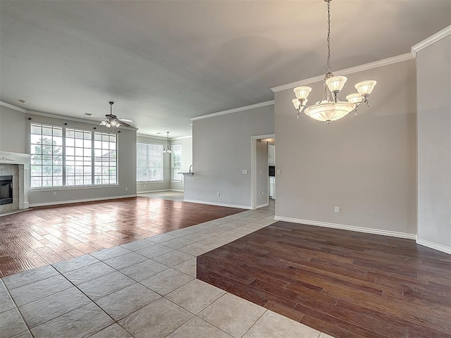16104 Ledge Ln, Edmond, OK 73013 - unfurnished living room featuring a chandelier, ornamental molding, wood finished floors, a tiled fireplace, and ceiling fan