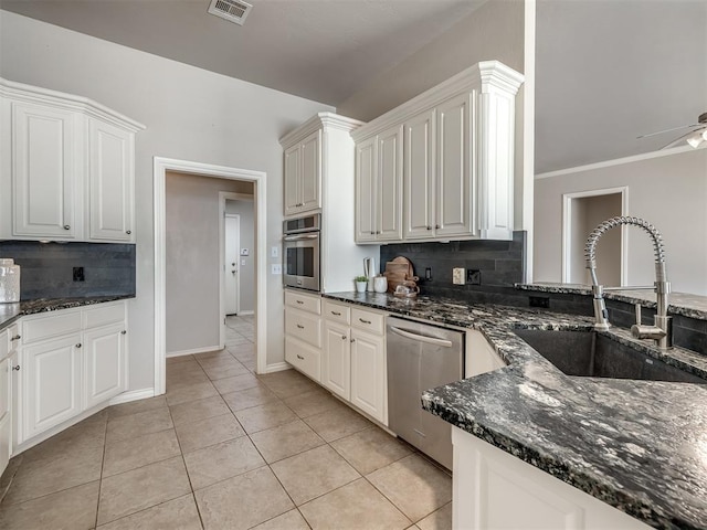 16104 Ledge Ln, Edmond, OK 73013 - kitchen featuring stainless steel appliances, a sink, tasteful backsplash, and dark stone counters