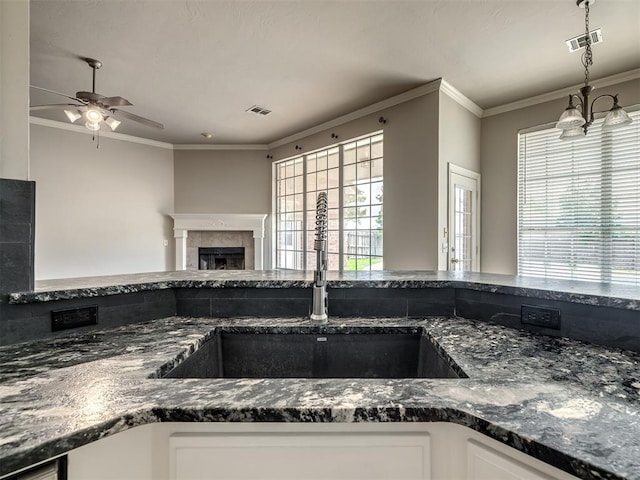 16104 Ledge Ln, Edmond, OK 73013 - kitchen with a sink, ornamental molding, ceiling fan, dark stone counters, and white cabinetry