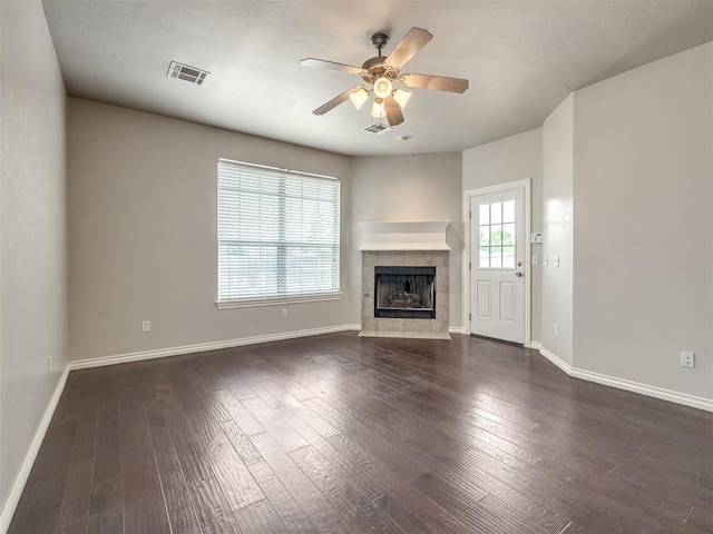 16104 Ledge Ln, Edmond, OK 73013 - unfurnished living room featuring a ceiling fan, a tiled fireplace, baseboards, and dark wood-style floors