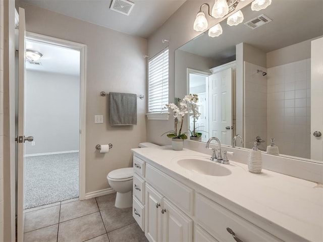 16104 Ledge Ln, Edmond, OK 73013 - full bathroom with toilet, vanity, tile patterned floors, tiled shower, and baseboards