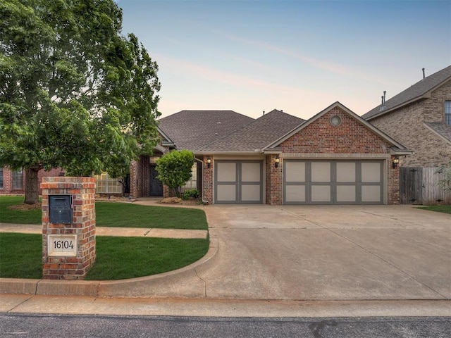 16104 Ledge Ln, Edmond, OK 73013 - view of front of property with an attached garage, concrete driveway, brick siding, and a shingled roof