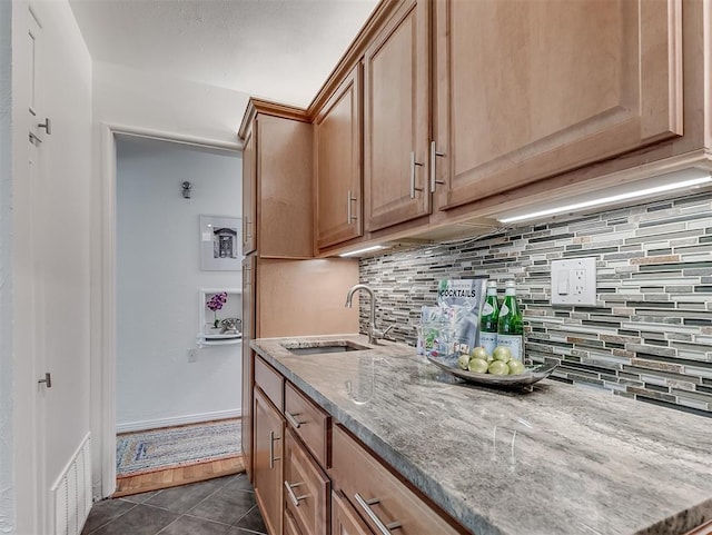 1738 Westchester Dr, Oklahoma City, OK 73120 - kitchen featuring a sink, decorative backsplash, light stone countertops, and dark tile patterned floors