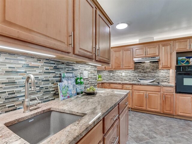 1738 Westchester Dr, Oklahoma City, OK 73120 - kitchen featuring black appliances, a sink, under cabinet range hood, and backsplash