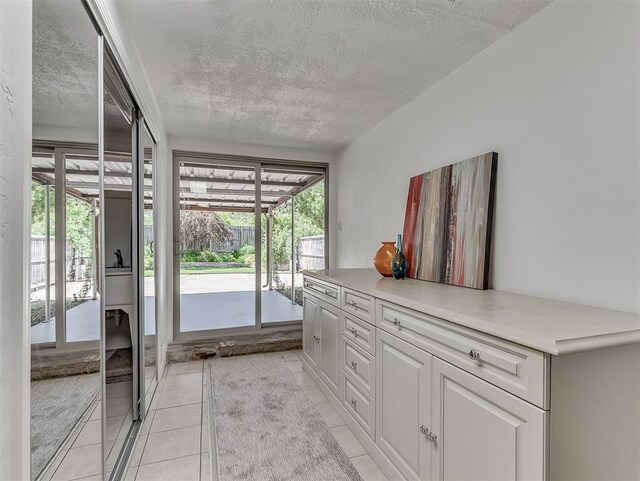 1738 Westchester Dr, Oklahoma City, OK 73120 - doorway with a textured ceiling, healthy amount of natural light, and light tile patterned flooring