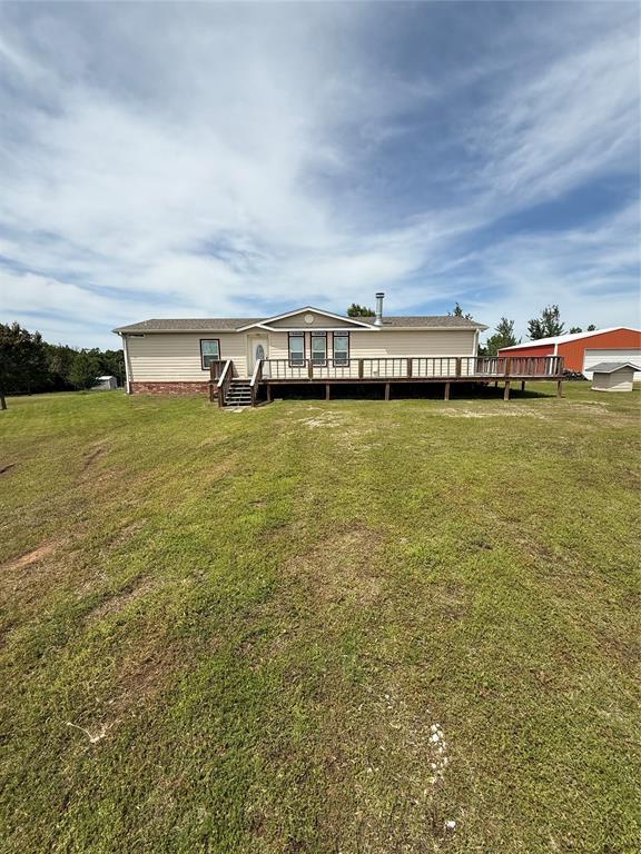 106 Sundown Ct, Mcloud, OK 74851 - rear view of house featuring a deck and a lawn