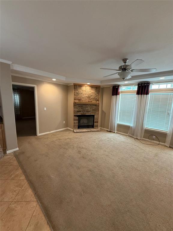 106 Sundown Ct, Mcloud, OK 74851 - unfurnished living room with crown molding, a ceiling fan, a fireplace, baseboards, and light carpet