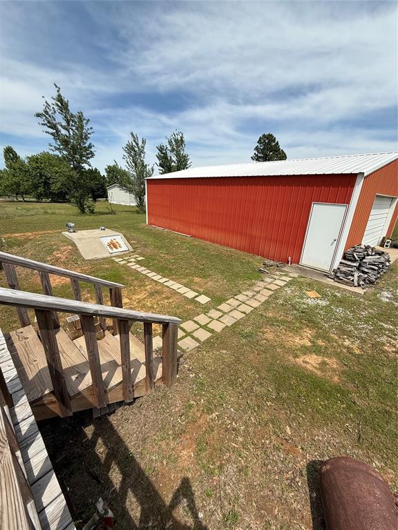 106 Sundown Ct, Mcloud, OK 74851 - view of green lawn featuring a pole building and an outbuilding