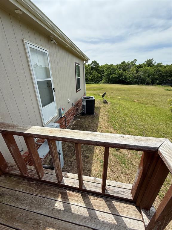 106 Sundown Ct, Mcloud, OK 74851 - deck featuring central air condition unit and a lawn