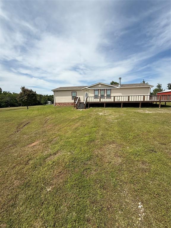 106 Sundown Ct, Mcloud, OK 74851 - rear view of house featuring a wooden deck and a yard