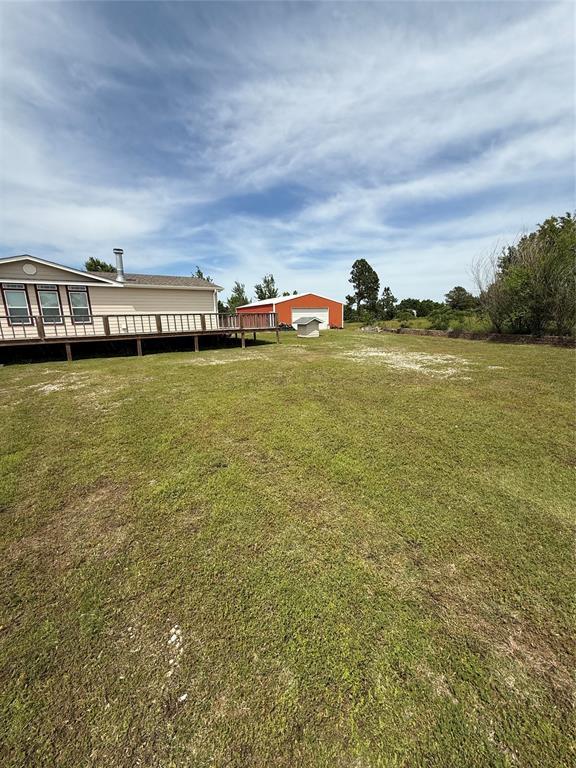 106 Sundown Ct, Mcloud, OK 74851 - view of grassy yard with a deck and a detached garage