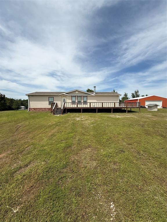 106 Sundown Ct, Mcloud, OK 74851 - rear view of property with a wooden deck and a lawn
