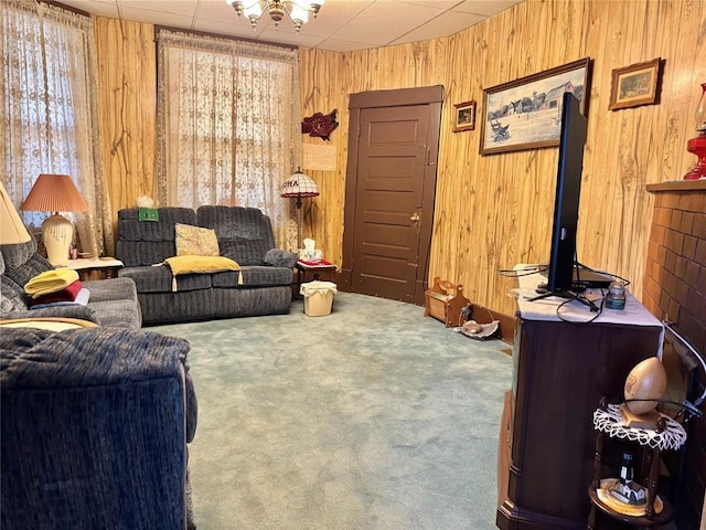 living room with carpet flooring, plenty of natural light, and wood walls