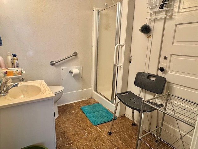 bathroom with a stall shower, toilet, and vanity