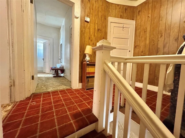 hallway featuring wooden walls