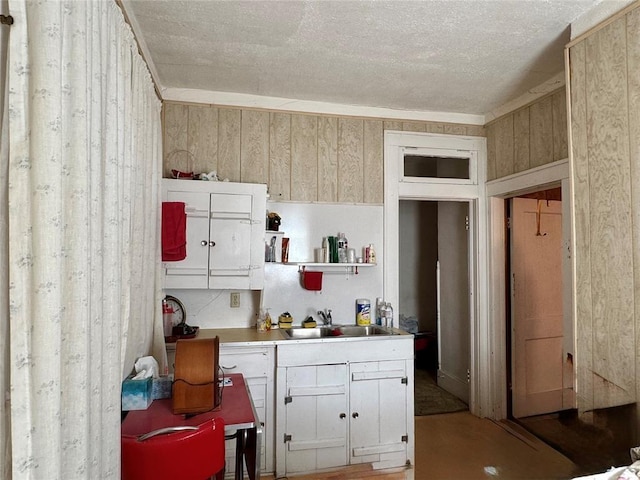 kitchen featuring a sink, open shelves, and a textured ceiling