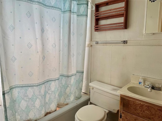 full bathroom featuring tile walls, toilet, vanity, shower / bath combination with curtain, and a wainscoted wall