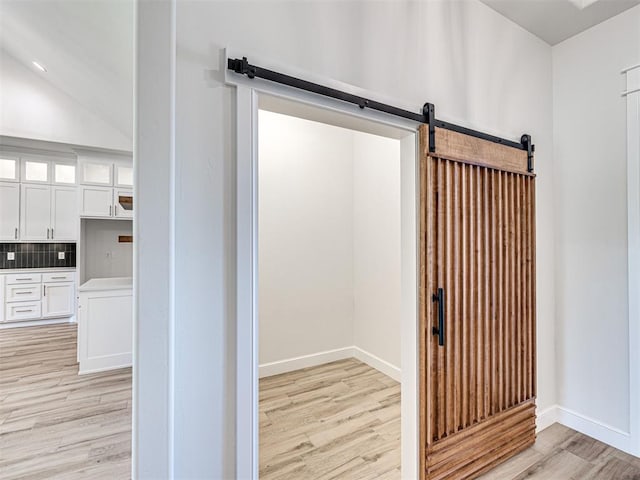 10424 SW 51st St, Mustang, OK 73064 - detailed view of a barn door, wood finished floors, decorative backsplash, and baseboards
