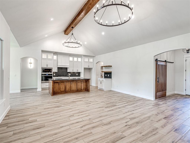 10424 SW 51st St, Mustang, OK 73064 - kitchen featuring stainless steel appliances, a chandelier, a barn door, open floor plan, and beam ceiling