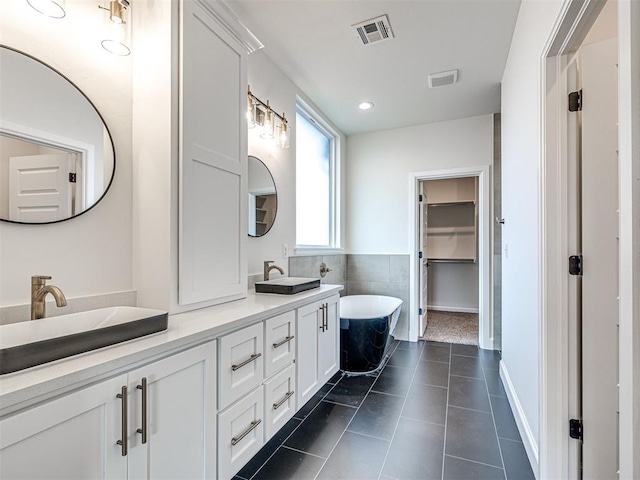 10424 SW 51st St, Mustang, OK 73064 - bathroom featuring a freestanding bath, double vanity, a spacious closet, and recessed lighting