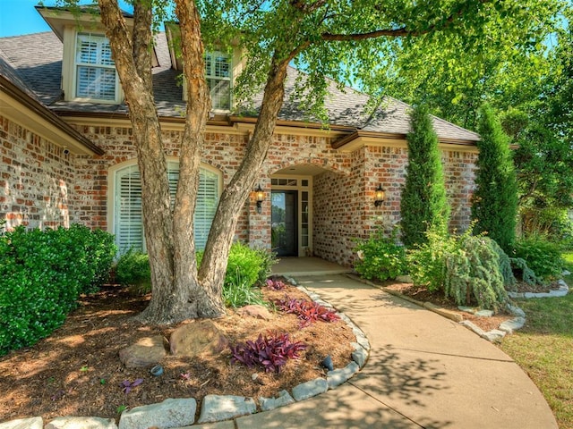 3605 Abbotsford, Norman, OK 73072 - doorway to property featuring brick siding and roof with shingles
