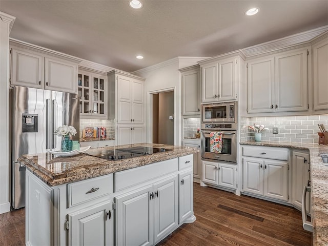 3605 Abbotsford, Norman, OK 73072 - kitchen featuring appliances with stainless steel finishes, tasteful backsplash, a kitchen island, light stone countertops, and ornamental molding