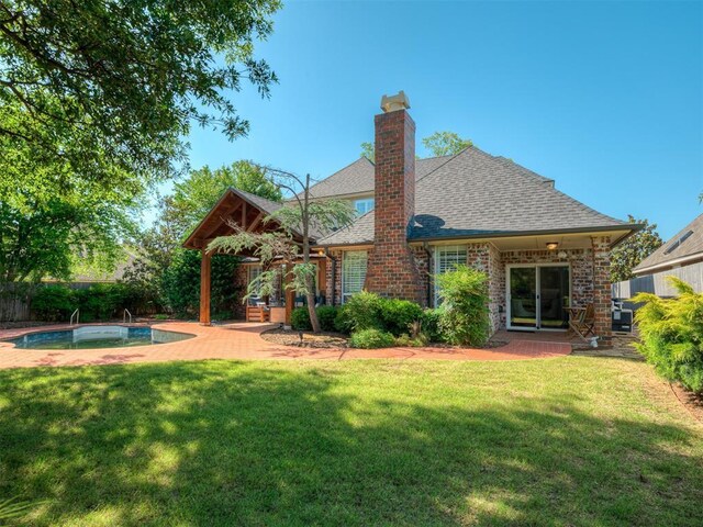 3605 Abbotsford, Norman, OK 73072 - back of property featuring roof with shingles, a patio area, brick siding, and a chimney