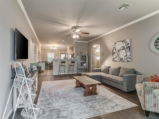 2536 Canyon Creek Dr, Yukon, OK 73099 - living room with ornamental molding, a ceiling fan, dark wood-style floors, a chandelier, and arched walkways