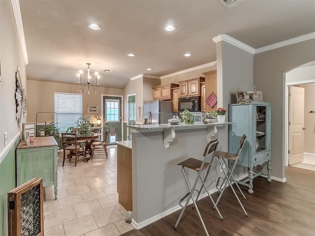 2536 Canyon Creek Dr, Yukon, OK 73099 - kitchen with black microwave, stainless steel fridge with ice dispenser, ornamental molding, a breakfast bar area, and recessed lighting