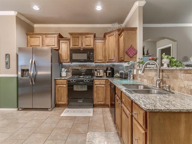 2536 Canyon Creek Dr, Yukon, OK 73099 - kitchen featuring black appliances, a sink, crown molding, tasteful backsplash, and light stone counters
