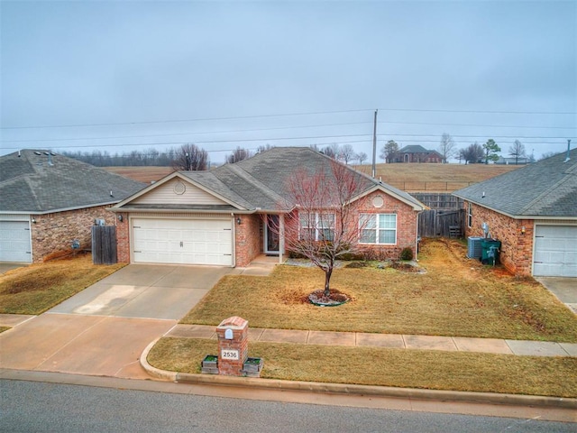 2536 Canyon Creek Dr, Yukon, OK 73099 - ranch-style house with an attached garage, driveway, brick siding, and central AC
