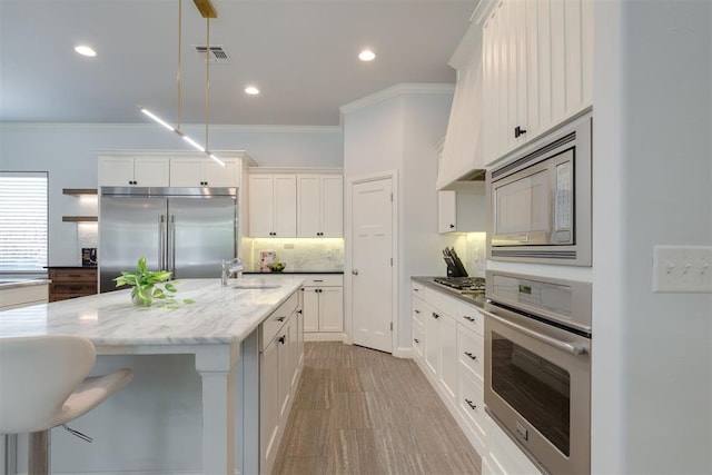 3419 Abby Ln, Newcastle, OK 73065 - kitchen featuring built in appliances, crown molding, a sink, white cabinetry, and backsplash