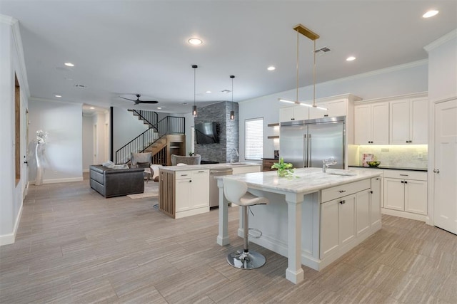 3419 Abby Ln, Newcastle, OK 73065 - kitchen with stainless steel appliances, open floor plan, an island with sink, decorative backsplash, and white cabinets