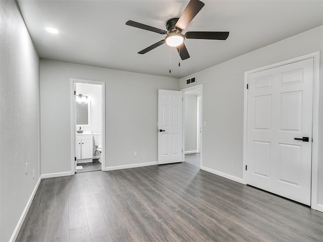 3325 NW 65th St, Oklahoma City, OK 73116 - unfurnished bedroom with dark wood-style flooring, baseboards, connected bathroom, and ceiling fan