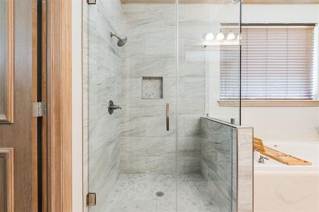 bathroom featuring a bath and a shower stall