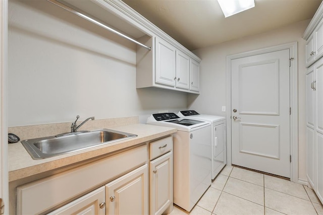 laundry room with washer and clothes dryer, cabinet space, and light tile patterned floors